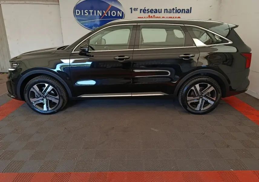 Vue de profil côté gauche du KIA Sorento noir 2023 hybride rechargeable, avec jantes alliage et toit chromé.