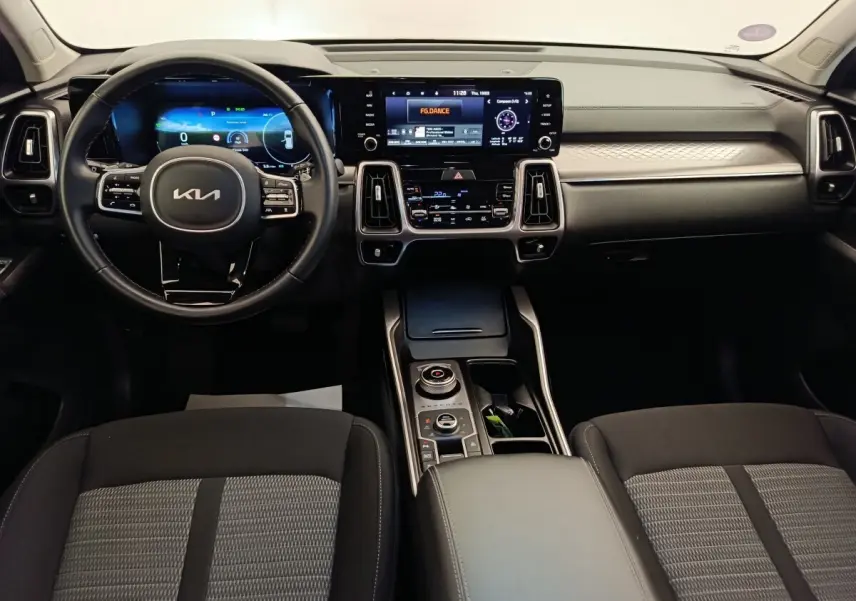 Vue intérieure avant du tableau de bord du Kia Sorento 2023 avec écran tactile et volant cuir noir.
