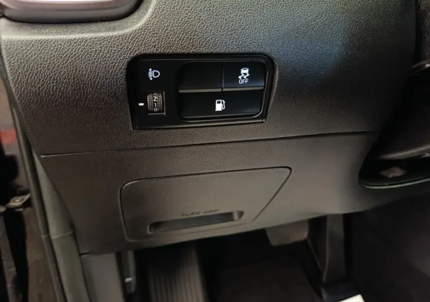 Gros plan sur les commandes noires du tableau de bord côté gauche du Kia Sorento noir 2023 hybride rechargeable.