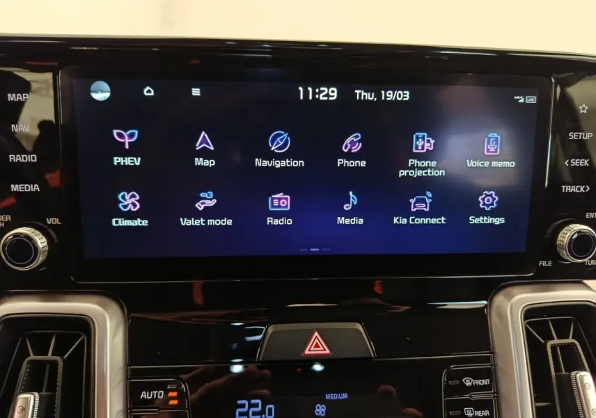 Écran tactile central du tableau de bord du Kia Sorento noir 2023 affichant les options de navigation et climatisation.