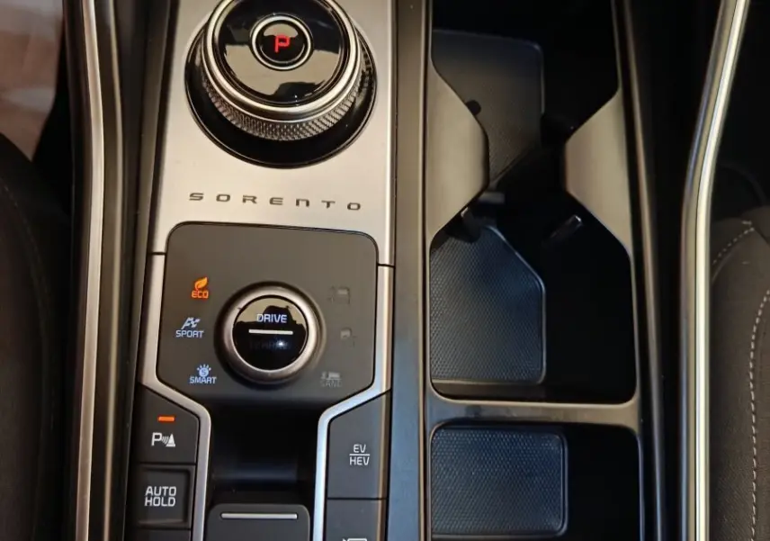 Gros plan sur la console centrale noire du Kia Sorento 2023 avec sélecteur rotatif de boîte auto et commandes de modes de conduite.