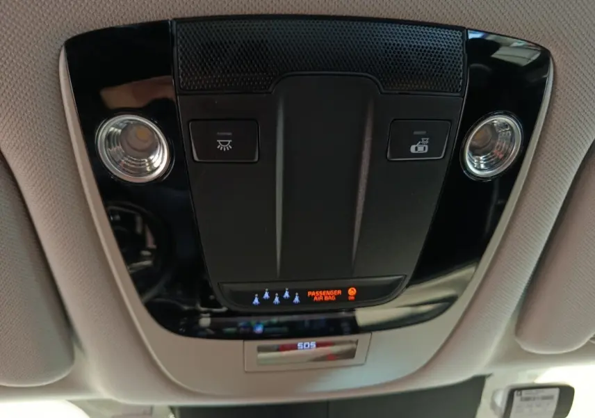 Vue en contre-plongée du plafonnier noir avec éclairages et indicateur airbag passager du Kia Sorento 2023 hybride.