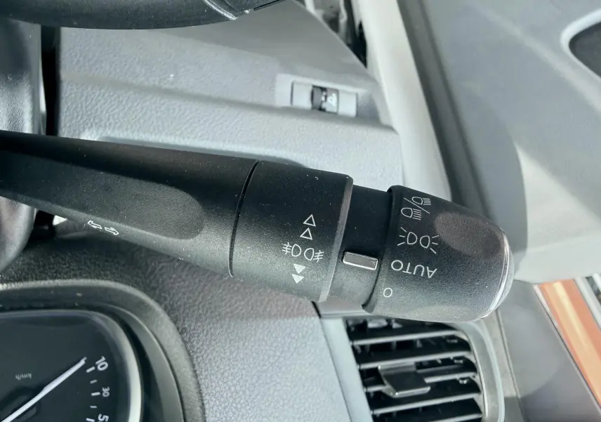 Gros plan sur la commande des phares et clignotants du Citroën Jumpy blanc, intérieur gris, côté gauche du volant.