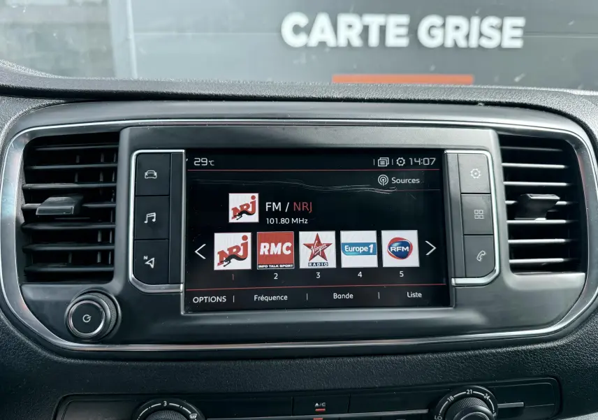 Vue rapprochée de l’écran multimédia central du Citroën Jumpy XL blanc, affichant les stations radio FM.