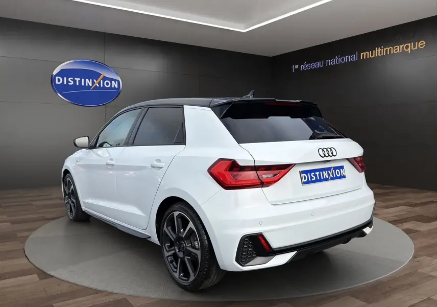 Audi A1 Sportback blanc vue 3/4 arrière droit avec toit noir et aileron de toit distinctif.