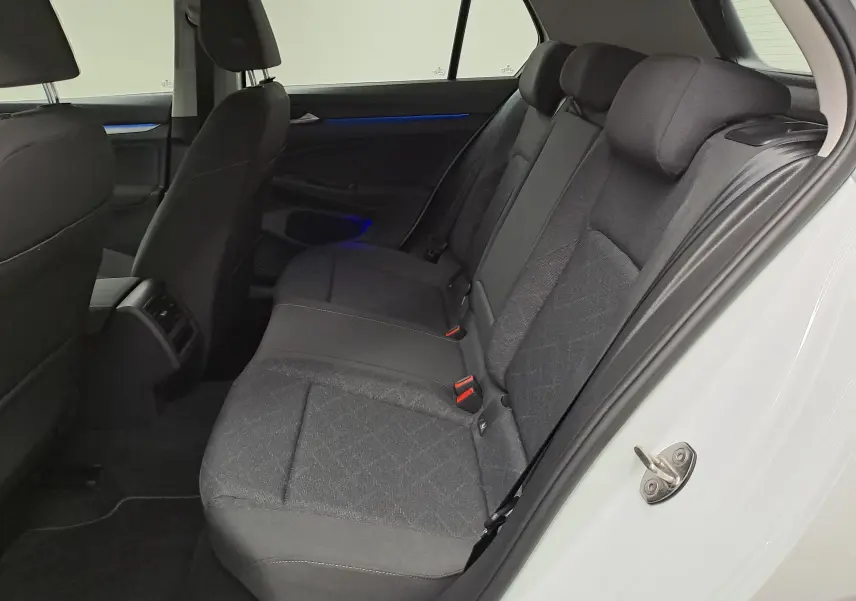 Vue intérieure côté droit des sièges arrière en tissu gris de la Volkswagen Golf 1.5 TSI 2022 blanche.