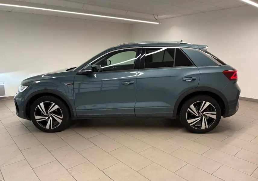 Volkswagen T-Roc 2024 bleu pétrole en vue profil côté gauche, avec jantes R-Line et vitres teintées.
