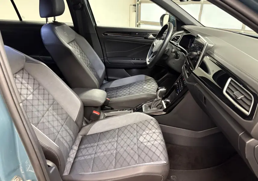 Vue intérieure côté conducteur du Volkswagen T-Roc 1.5 TSI R-Line 2024 avec sièges tissu et alcantara gris à motifs géométriques.