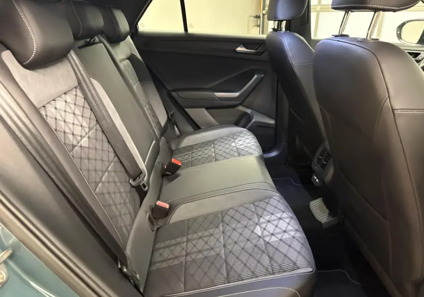 Vue intérieure des sièges arrière en tissu et cuir noir avec surpiqûres, Volkswagen T-Roc 2024 bleu pétrole.