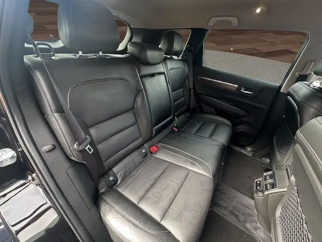 Vue intérieure côté gauche des sièges arrière en cuir noir du Renault Koleos 2017, avec détails des ceintures et aérateurs.