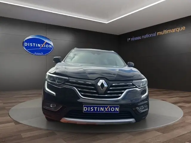 Vue frontale d'un Renault Koleos noir 2017 avec calandre chromée et feux LED allumés en showroom