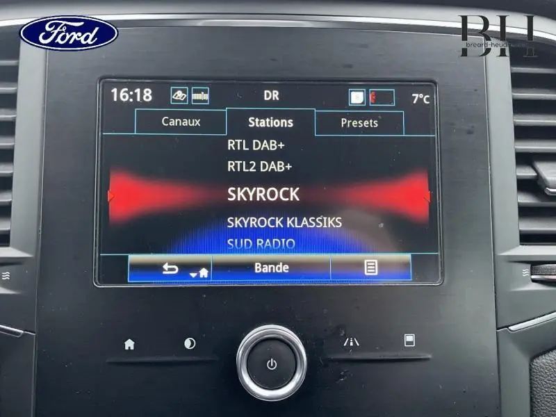 Écran tactile central du tableau de bord de la Renault Mégane Break gris platine, affichant les stations radio.