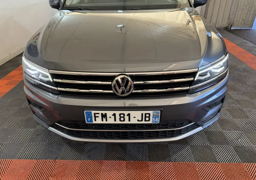 Vue avant rapprochée du Volkswagen Tiguan Allspace gris foncé avec phares LED allumés et calandre chromée.