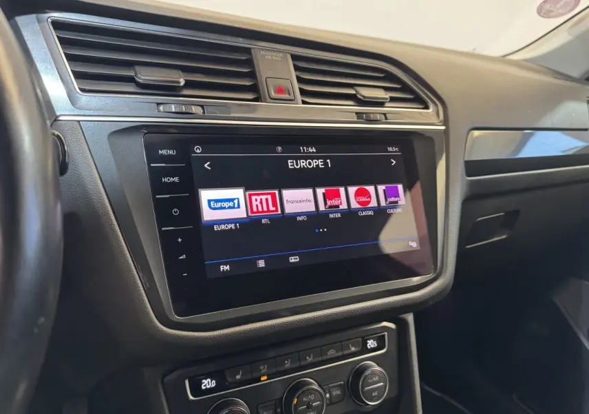 Vue intérieure du tableau de bord du Volkswagen Tiguan Allspace 2019 avec écran tactile affichant les radios, finition noire.