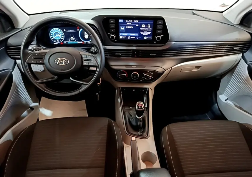 Vue intérieure avant de la Hyundai i20 2022, tableau de bord moderne avec écran tactile et volant cuir multifonctions.