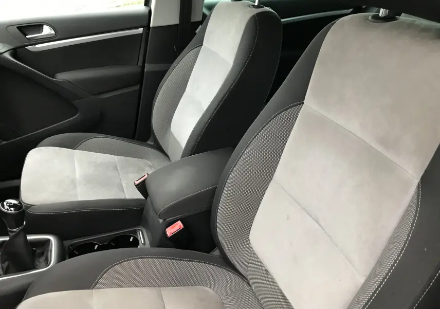 Intérieur du Volkswagen Tiguan Sportline 2012, sièges tissu gris clair et foncé, levier de vitesse manuel visible côté gauche.