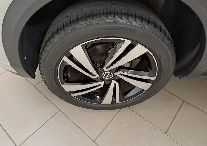 Gros plan sur la jante alliage bicolore noire et argentée du Volkswagen T-Roc 2024 Gris Ascot, côté roue avant.