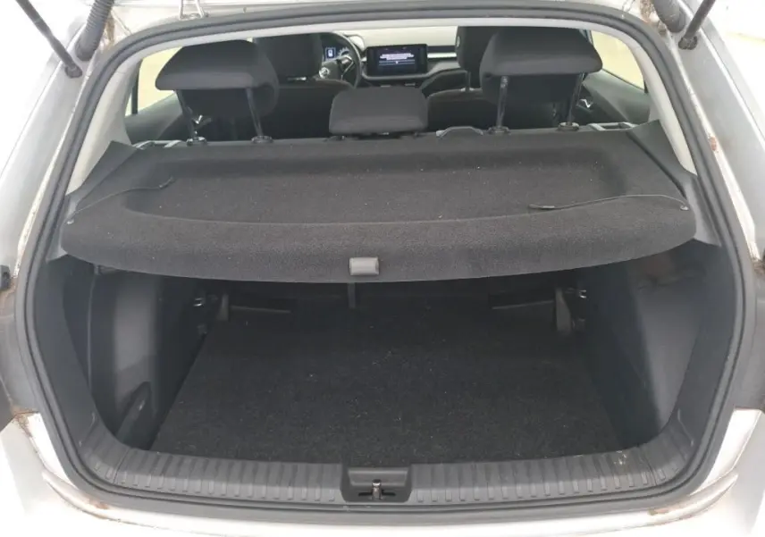 Vue arrière du coffre ouvert d'une Skoda Fabia gris 2023, avec la plage arrière en place et l'intérieur visible.