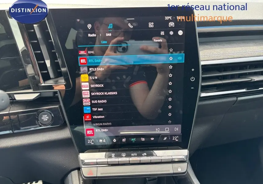 Tableau de bord du Renault Austral 2024 avec écran tactile central affichant les stations radio, finition noire et détails chromés.
