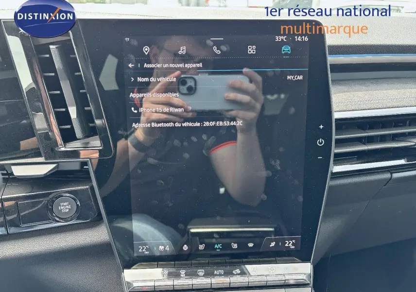 Vue rapprochée de l'écran tactile central du tableau de bord du Renault Austral 2024 bleu Iron Metal avec toit noir.