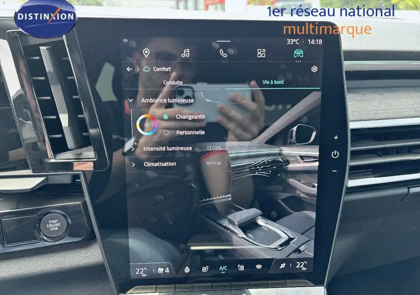 Vue intérieure du tableau de bord et écran tactile central du Renault Austral 2024 bleu Iron Metal avec toit noir.