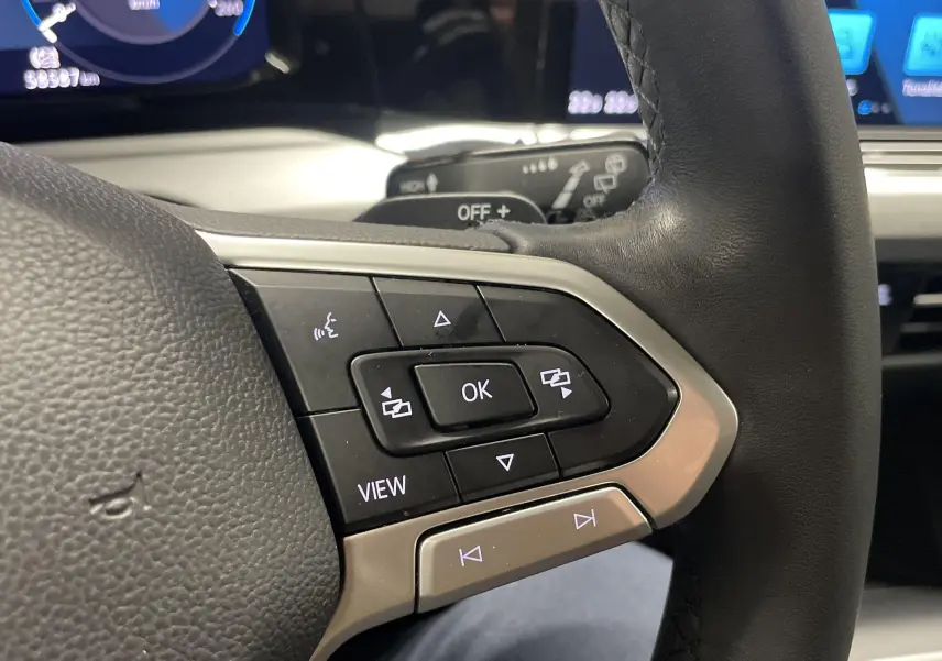 Gros plan sur les commandes multifonctions côté gauche du volant d'une Volkswagen Golf 2.0 TDI argentée de 2022.