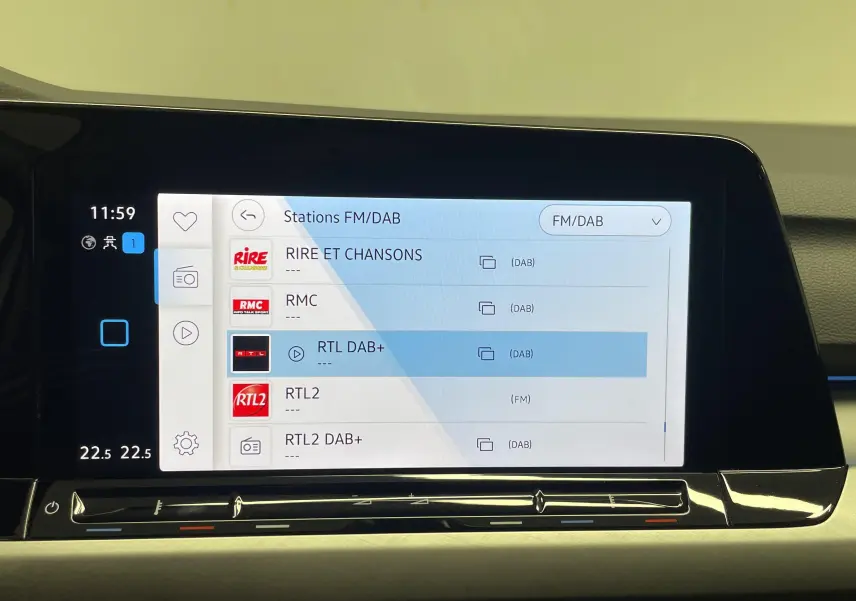 Écran tactile central de la Volkswagen Golf 2022 affichant les stations FM/DAB avec interface moderne et commandes tactiles.