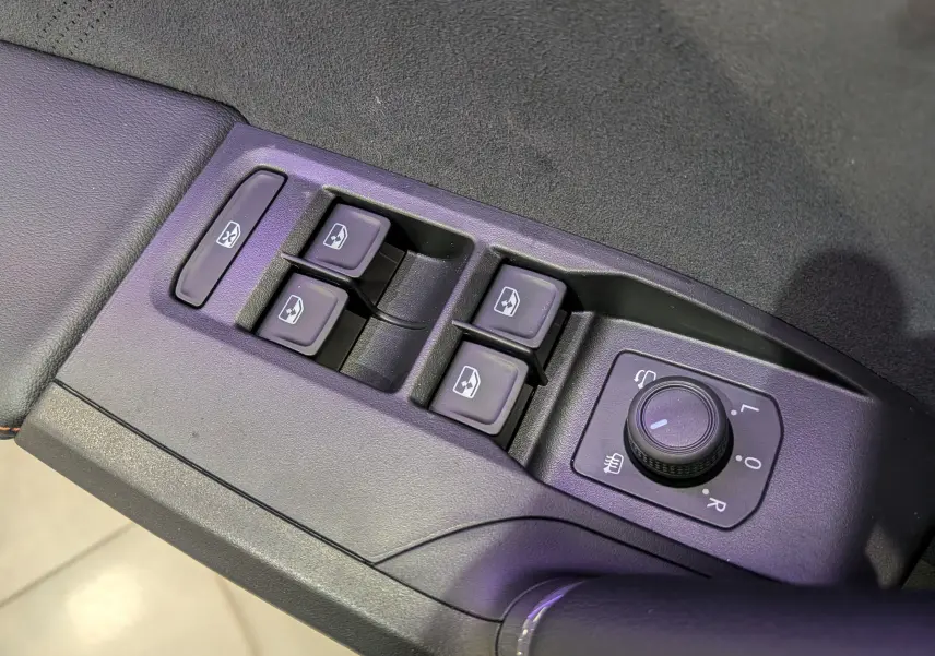 Gros plan sur les commandes de lève-vitres et réglage des rétroviseurs du CUPRA Formentor eHybrid noir Minuit, intérieur dynamique.