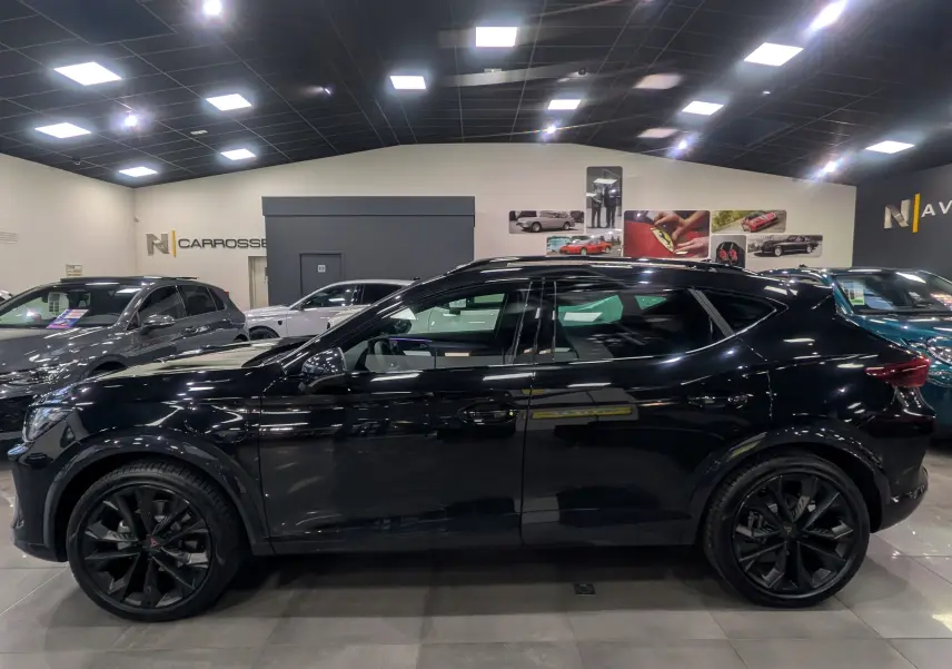 Vue de profil côté gauche du CUPRA Formentor eHybrid 204 CH noir minuit avec jantes noires en showroom.