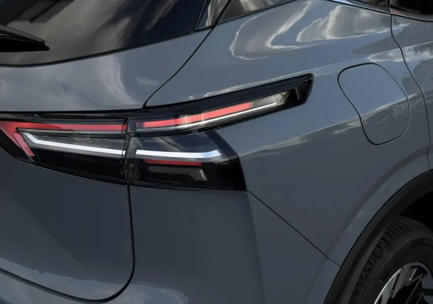 Gros plan sur le feu arrière droit du Nissan Qashqai 2025 gris Ceramic avec hayon électrique et lignes LED distinctives.