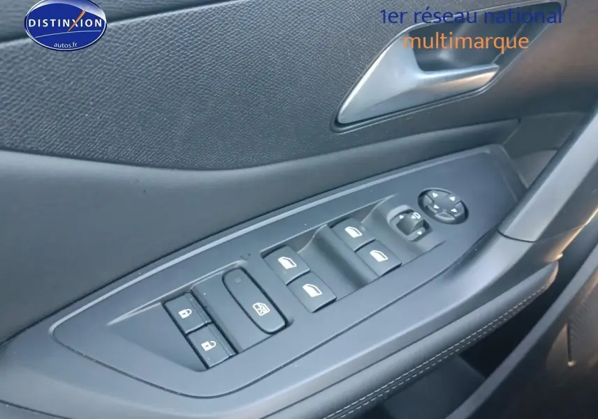 Gros plan sur la commande des vitres électriques côté conducteur de la Peugeot 408 Hybrid 145 gris sélénite.