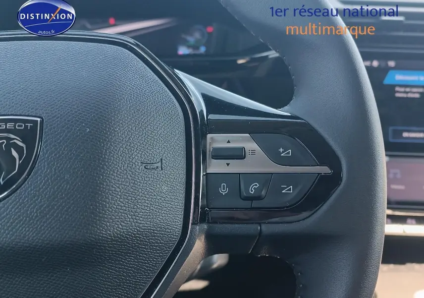 Gros plan sur le volant cuir noir du Peugeot 408 Hybrid 145 allure, avec commandes vocales et multimédia visibles.