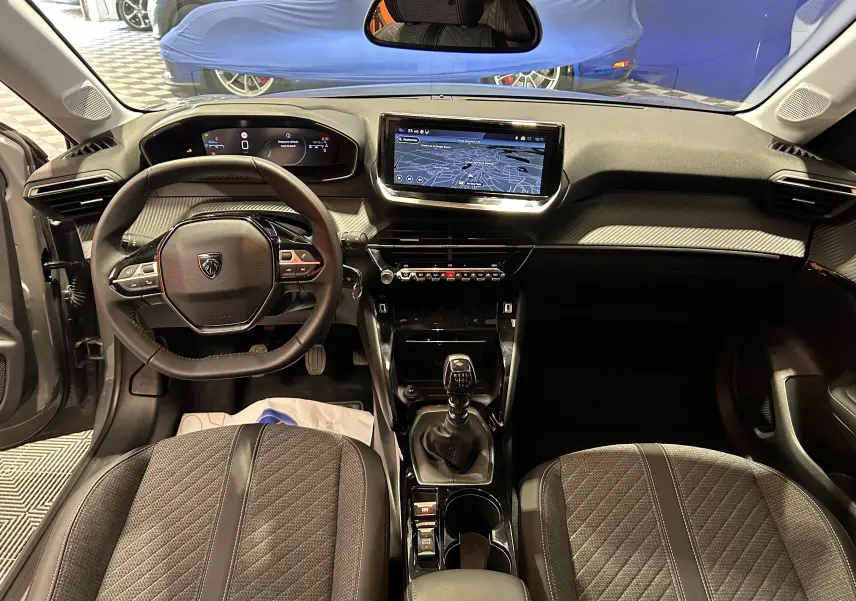 Intérieur Peugeot 208 Turbo 100 BVM6 Allure gris Selenium, vue frontale sur tableau de bord et écran GPS tactile.