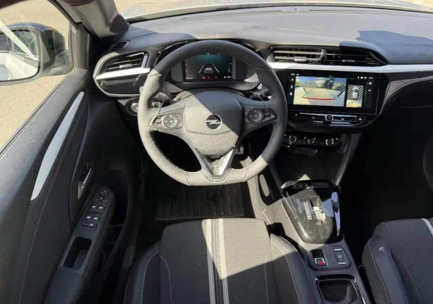 Vue intérieure de face du poste de conduite de l’Opel Corsa 1,2 Hybrid 2025 avec volant multifonction et écran tactile.