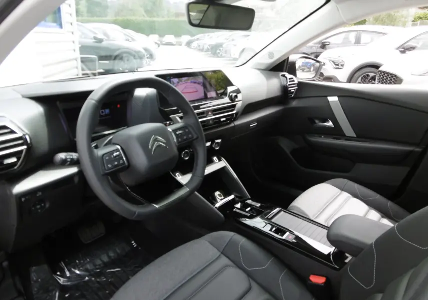 Intérieur moderne de Citroën C4 X blanc polaire, vue côté conducteur avec tableau de bord digital et volant multifonction.