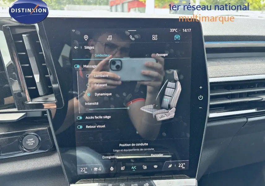 Vue intérieure centrée sur l'écran tactile du tableau de bord du Renault Austral 2024, finition bleu iron et toit noir.