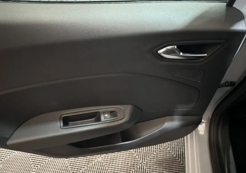Vue intérieure côté gauche de la porte avant gris clair de la Renault Clio Evolution Blue dCi 100 avec poignée et commande de vitre électrique.
