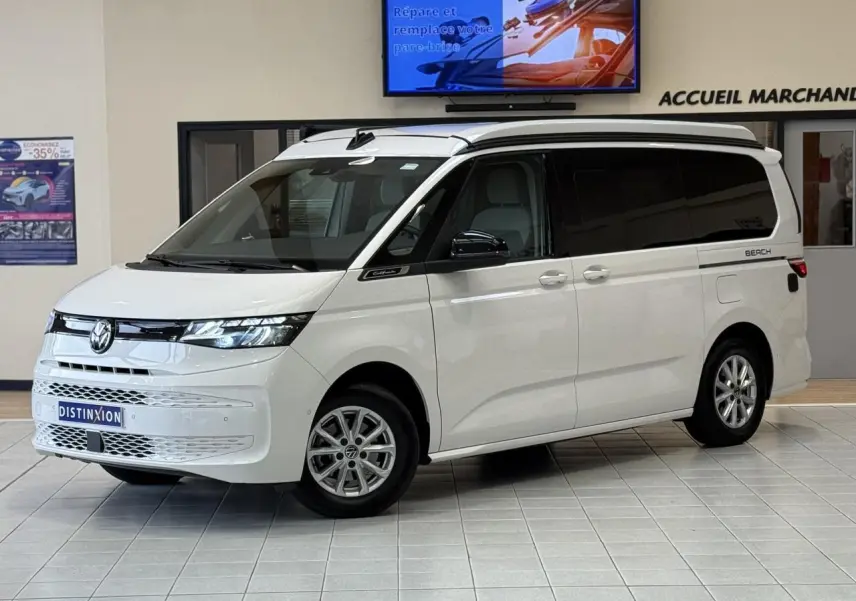 Volkswagen California T7 blanc Candy en 3/4 avant droit, avec vitres arrière teintées et toit relevable fermé.