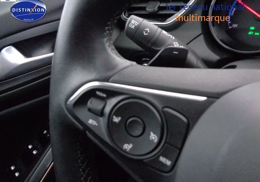 Gros plan sur le volant noir de l'Opel Grandland X 1.6 Hybrid Turbo 2021, avec commandes intégrées visibles.