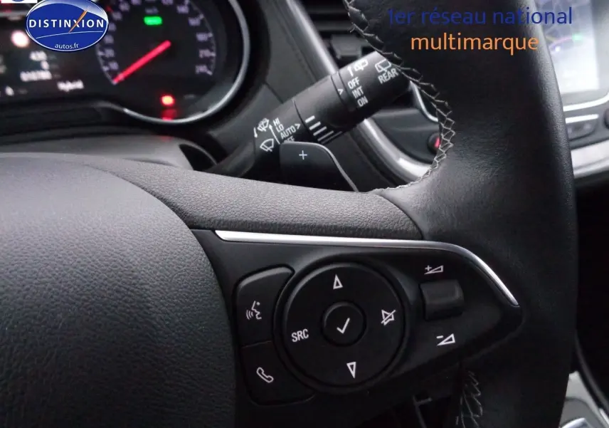 Gros plan sur les commandes du volant en cuir noir de l'Opel Grandland X blanc nacré hybride rechargeable.