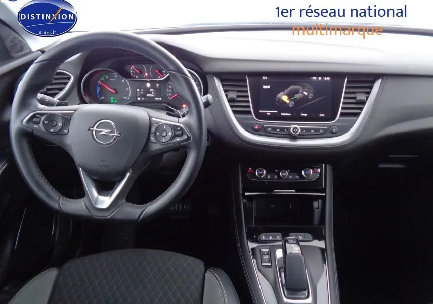 Intérieur de l'Opel Grandland X hybride 2021 vu de face, tableau de bord et volant en cuir noir visibles.