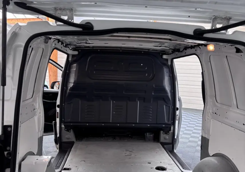 Vue intérieure arrière du Mercedes Vito blanc 111 CDI Compact 2 portes, montrant l’espace de chargement vide et la cloison pleine noire.