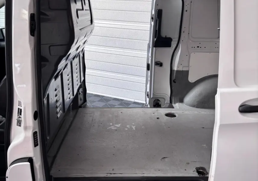 Vue intérieure du compartiment de chargement du Mercedes Vito 111 CDI Compact blanc, porte latérale ouverte.