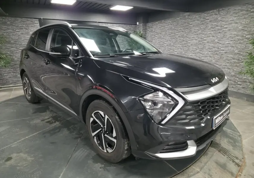 KIA Sportage noir vu en 3/4 avant droit, avec calandre noire laquée et jantes alliage 17 pouces.