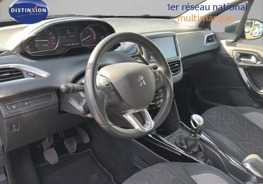 Intérieur de la Peugeot 2008 2019 essence gris platinium, vue du poste de conduite avec volant cuir et levier de vitesse manuel.