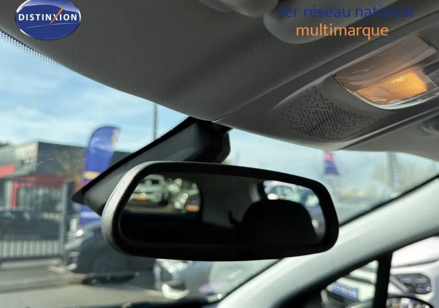 Rétroviseur intérieur montrant l'habitacle d'une Peugeot 2008 gris platinium en stationnement extérieur.