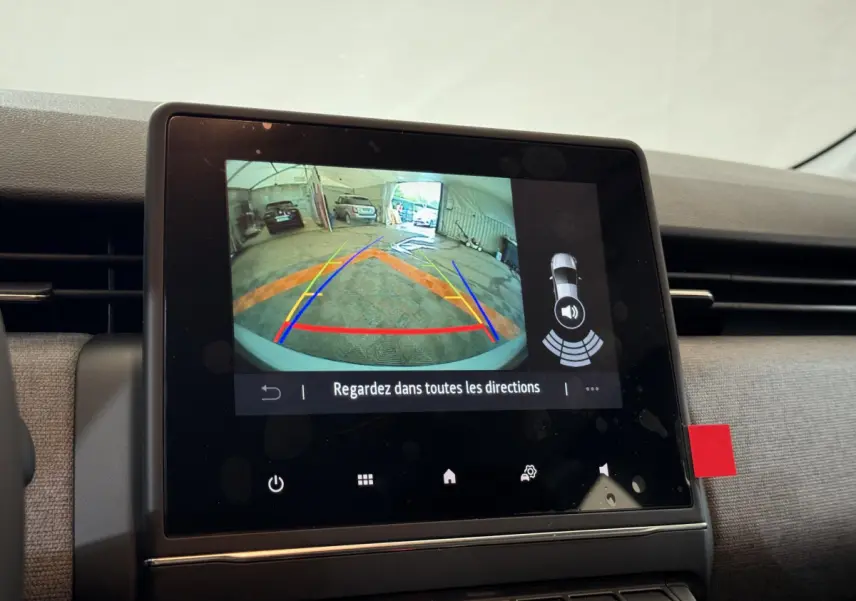 Écran tactile central de la Renault Clio 2025 montrant la caméra de recul avec guidage dynamique en intérieur gris clair.