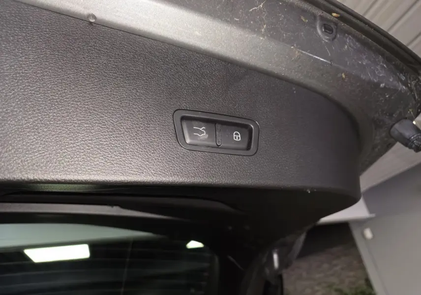 Gros plan sur le panneau intérieur noir du hayon électrique d'une Alfa Romeo Tonale gris 2023 avec boutons de fermeture et verrouillage.