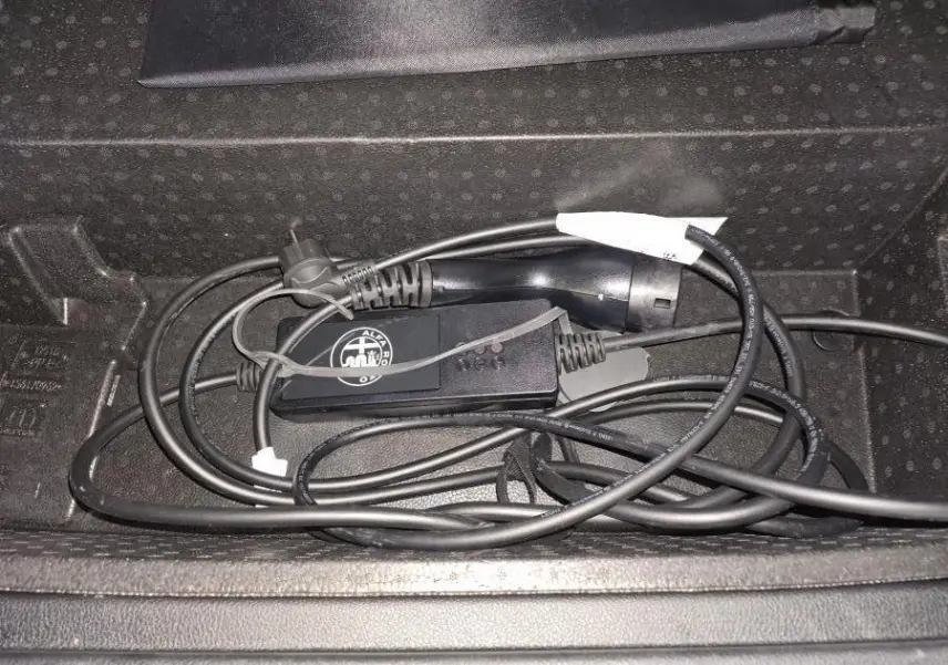 Câble de recharge Alfa Romeo Tonale hybride rechargeable rangé dans le coffre, vue rapprochée sur le câble noir.