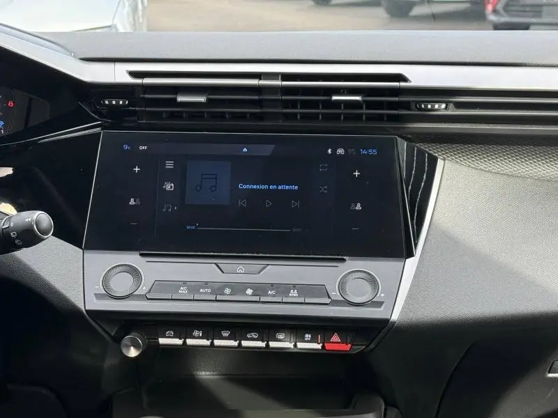 Vue intérieure du tableau de bord de la Peugeot 308 2024 en Noir Perla Nera, avec écran tactile et commandes climatisation.